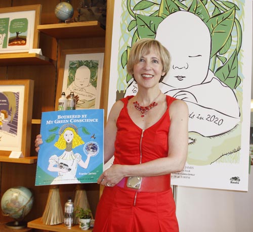 Franke James at book reading for Bothered by My Green Conscience, holding large copy of book for presentation; photo by Central Image Agency