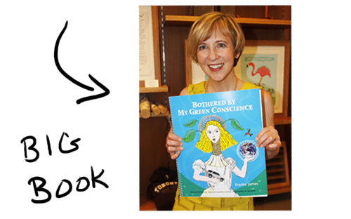 Franke James holding big book copy of Bothered by My Green Conscience; photo by Central Image Agency